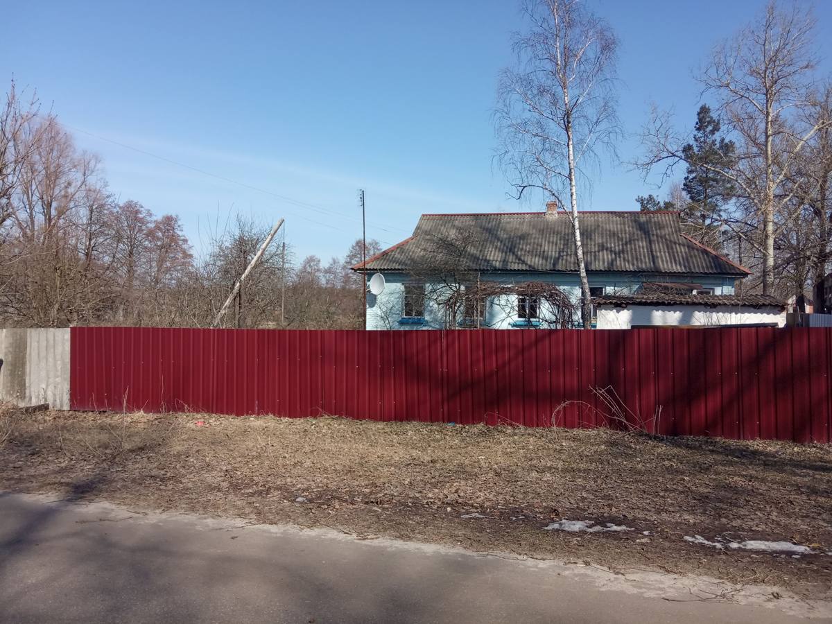 Забор из бордового профнастила вдоль улицы